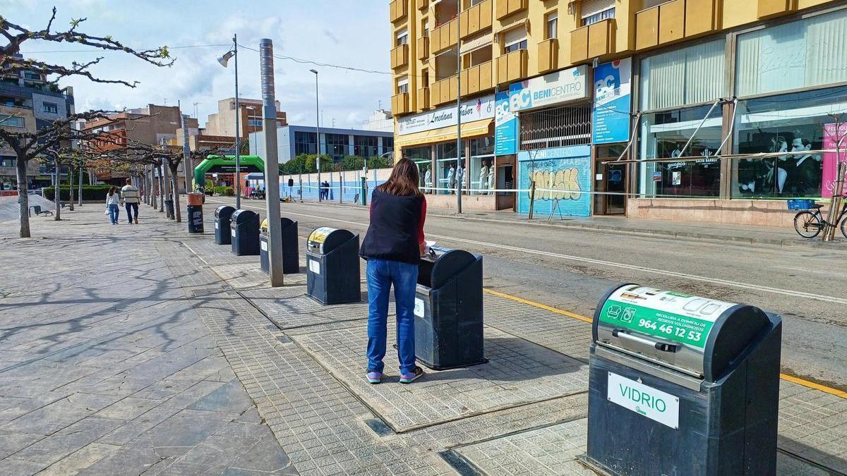 Una mujer deposita residuos en una isleta de contenedores en Benicarló.