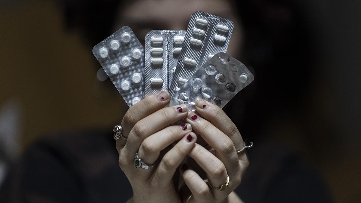 Una mujer sostiende diversos tipos de pastillas ansiolíticas