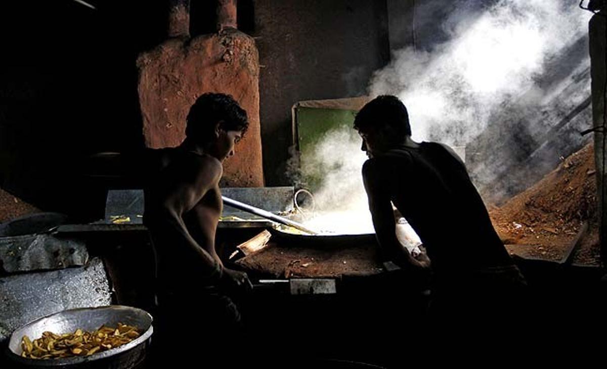 Dos empleats treballen en una fàbrica de xips de plàtan a Mumbai (Índia).