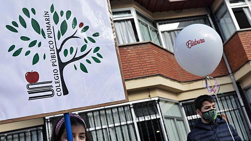 Por la izquierda, alumnos del colegio Pumarín despidiéndose del globo de helio que llevaba el antiguo nombre del centro; Sofía Suárez y Carlos Blanco, con el nuevo logo del centro y el globo de despedida, y vista general de los niños reunidos ayer en el patio, separados por clases para evitar contagios. | Juan Plaza | JUAN PLAZA