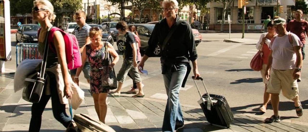 Un grupo de turistas con maletas en Palma buscando alojamiento para pernoctar.