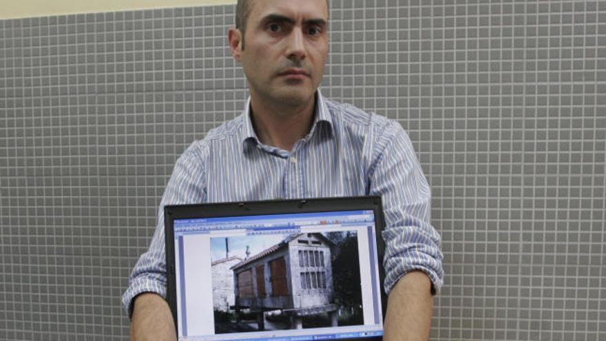 El investigador César Saá, con una imagen de un hórreo. // Carmen Giménez