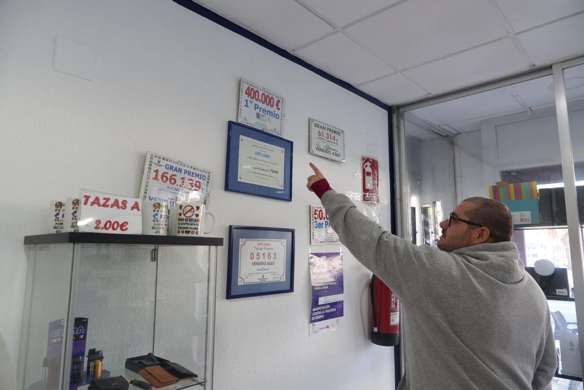 Trabajador de 'El Duende' señalando el diploma de Primer Premio de la Lotería de Navidad de 2012