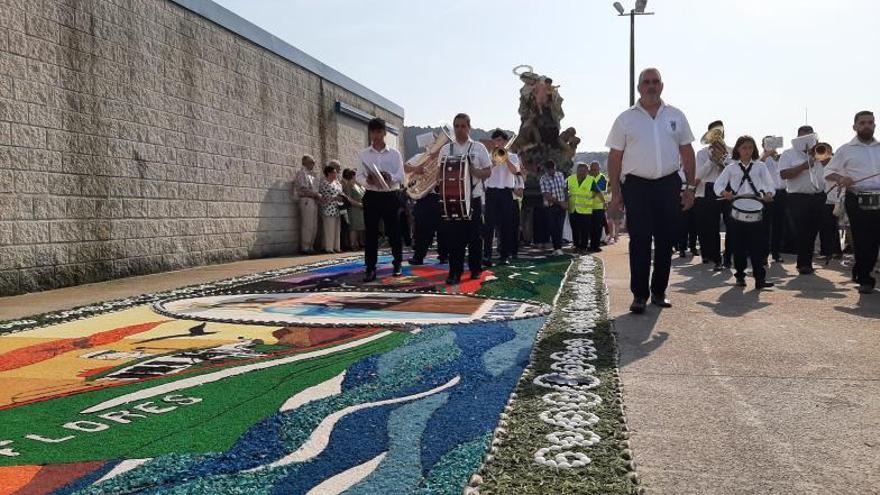 La imagen de la Virgen del Carmen de Bueu pasa por la alfombra elaborada en su honor.