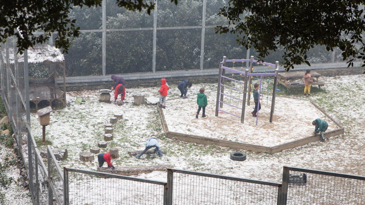 Niños jugando con la nieve en el patio de una escuela en el Montseny