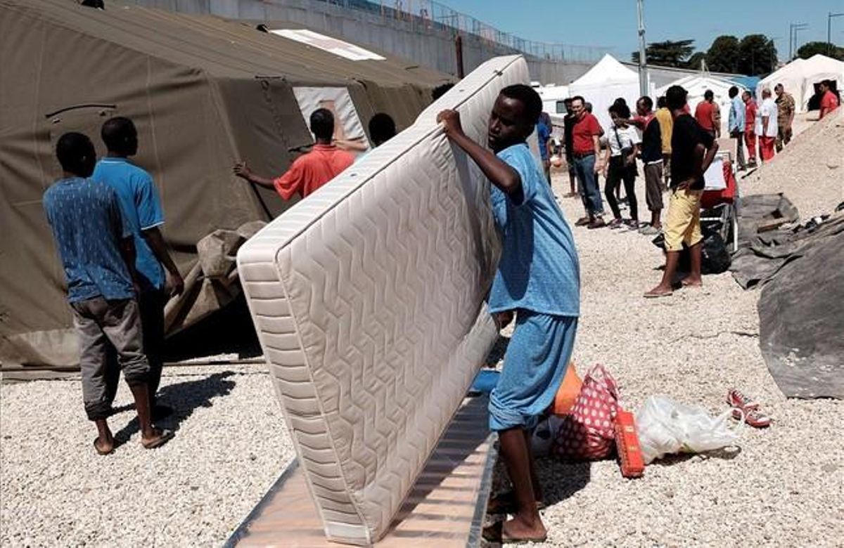 Un immigrant carrega un matalàs al camp de refugiats pròxim a l’estació de tren de Tiburtina, a Roma, el 20 d’agost.