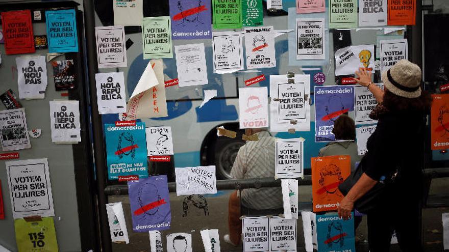 Una mujer mira los carteles sobre el referéndum, en Barcelona.