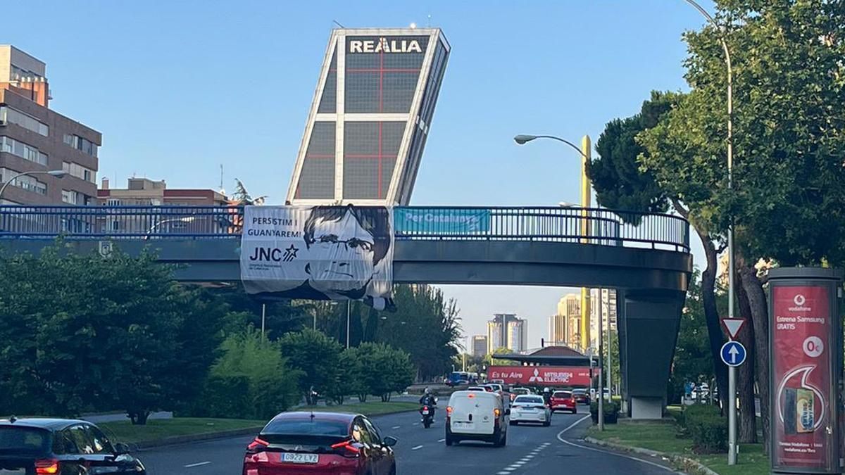 La pancarta amb la cara de Puigdemont penjada en un pont a prop de les popularment conegudes com a Torres Kio