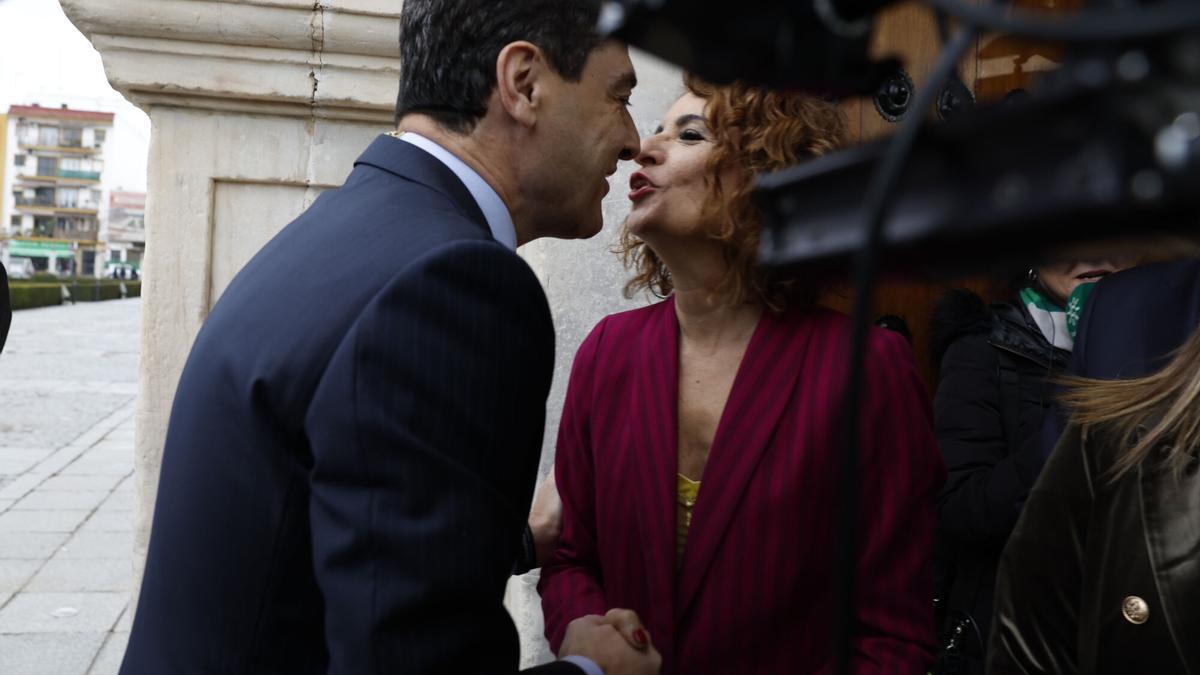 El presidente de la Junta de Andalucía, Juanma Moreno, saluda a la vicepresidenta primera del Gobierno y ministra de Hacienda, María Jesús Montero, a su llegada al Parlamento.