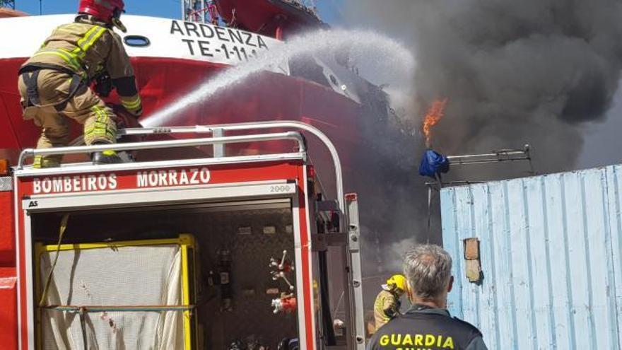 Los bomberos trabajan en la extinción de un incendio en el astillero moañés Industrias Navales