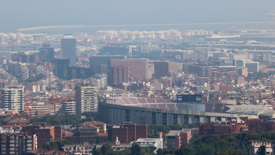 Barcelona amb el Camp Nou en primer pla i el port de fons amb boira per pol·lució