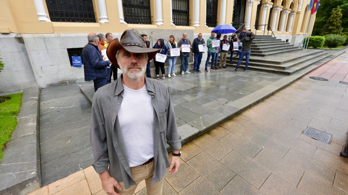 Xuan Valladares y detrás, los ganaderos encadenados ante la sede del Gobierno.