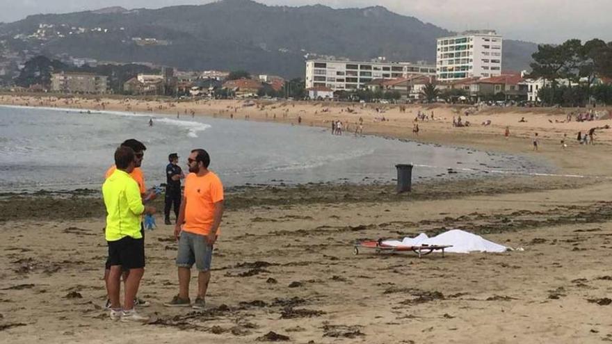 Protección Civil y Policía Local custodian el cuerpo, ayer, en Praia América.