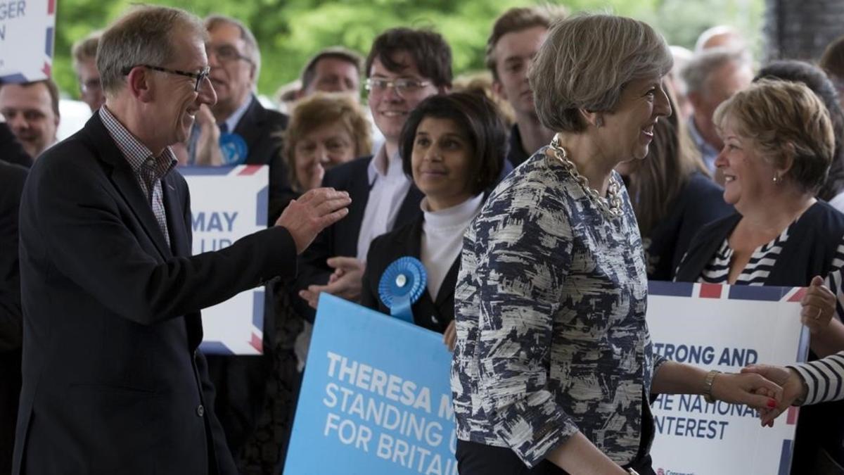 La primera ministra britanica y lider del Partido Conservador, Theresa May, saluda a sus partidarios a su llegada a un acto de campaña