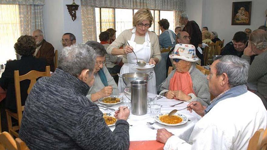 Usuarios del comedor social de Emaús en Antequera, junto a una trabajadora.