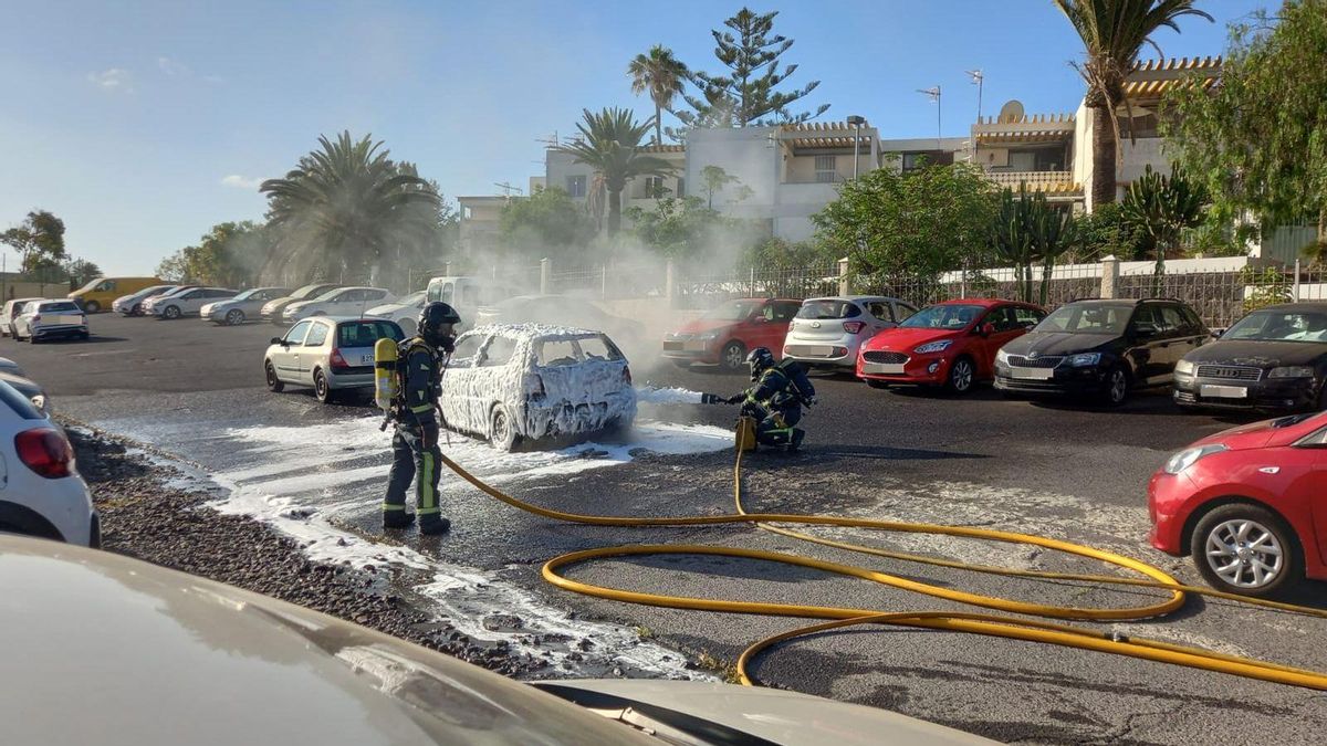 Bomberos sofocando las llamas del vehículo