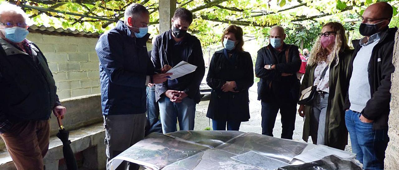 Los técnicos muestran los planos del monte vecinal en mano común de Ferreira a los vecinos. | D. Á.