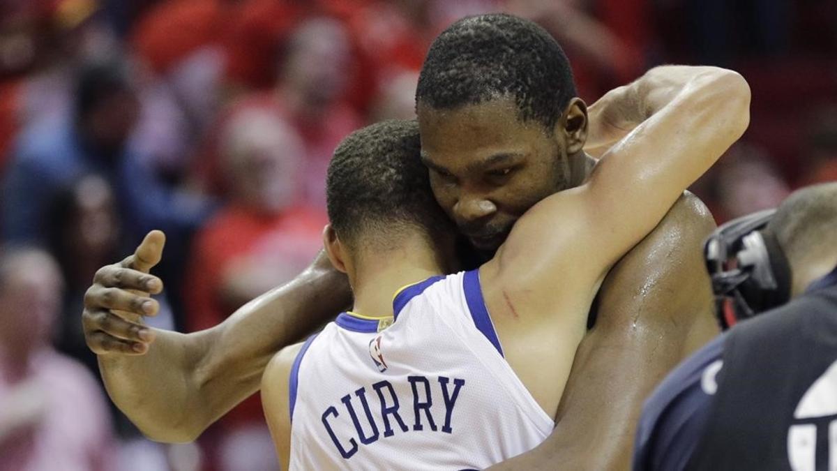 Kevin Durant abraza a Stephen Curry (de espaldas) después de que los Warriors derrotaran a los Rockets.