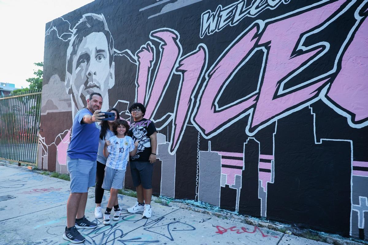 Algunos aficionados de Miami se fotografian con el mural de Messi