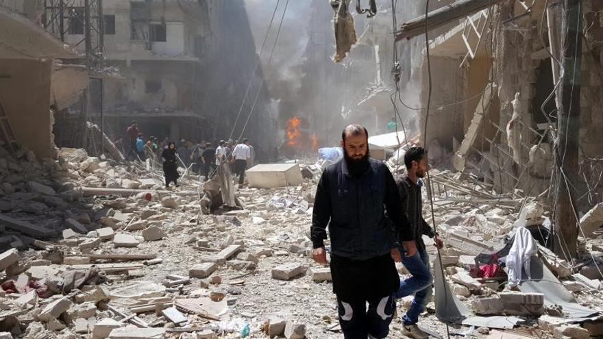 Varias personas en una zona de Alepo bombardeada.
