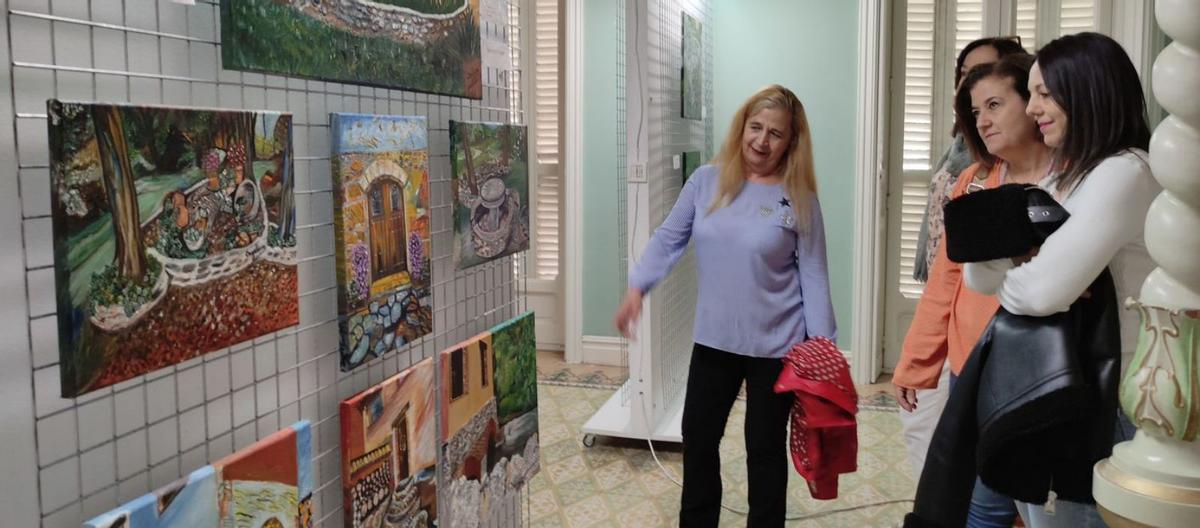 Visitantes de la muesra observan algunos de los cuadros de la artista, en la sala de exposiciones. | E. P.