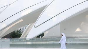 Un hombre camina frente al recinto que acoge la cumbre del clima de Dubái (COP28).
