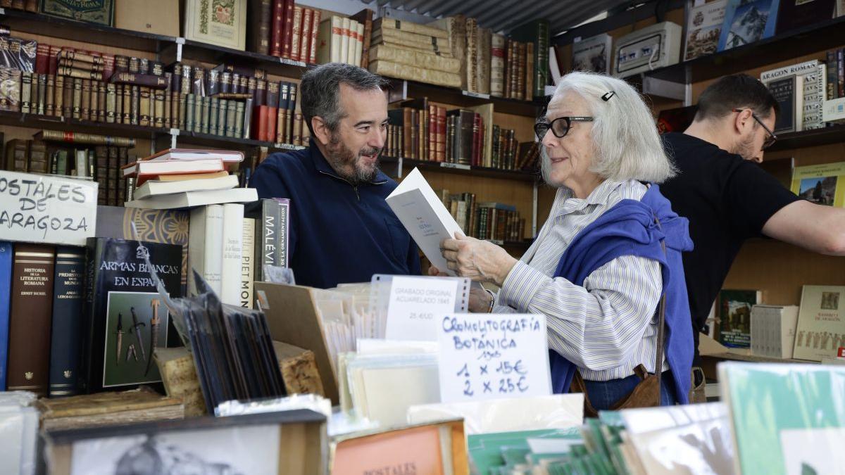 Nacho Asín, de la librería zaragozana Luces de Bohemia, charla este domingo con una clienta.