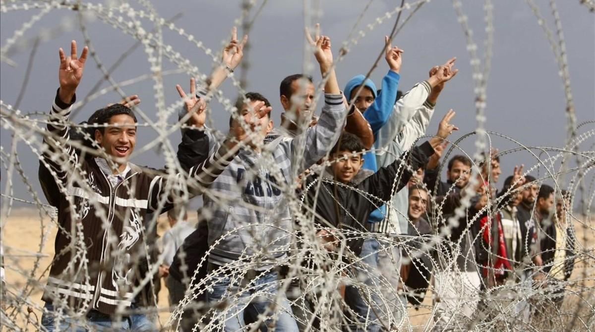 Un grupo de palestinos gesticulan a soldados israelís de guardia cerca de la valla entre Israel y la franja de Gaza, el 23 de noviembre del 2012.