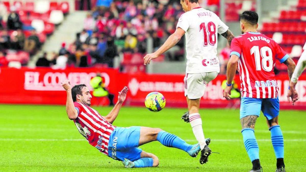 Cali Izquierdoz se lanza a  disputar el balón con Musto, del Cartagena, durante un partido. | Juan Plaza