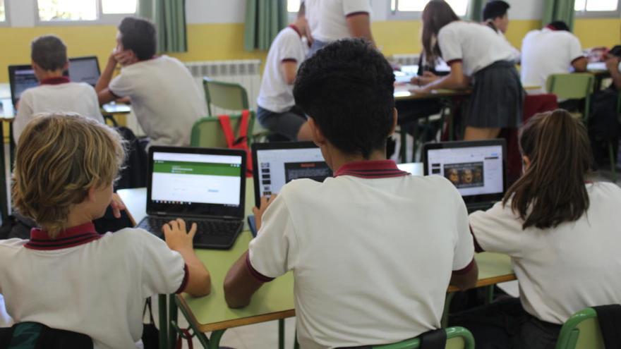 Alumnos con sus dispositivos Chromebook en clase
