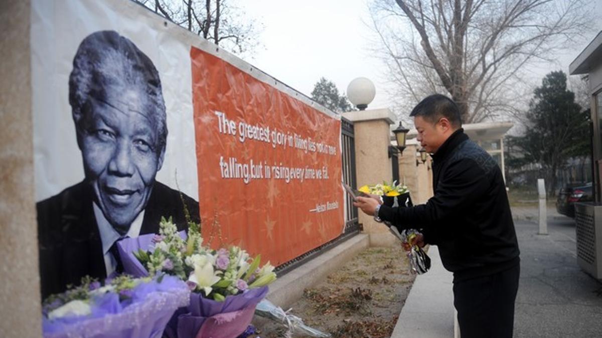 Un hombre deposita flores en memoria de Mandela ante la Embajada de Sudáfrica en Pekín, este viernes.
