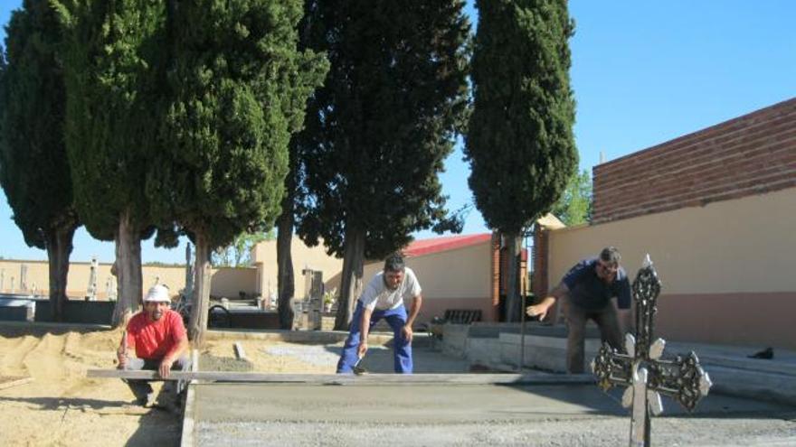 Tres operarios en la mañana de ayer realizando obras en el cementerio de Santa Cristina de la Polvorosa.