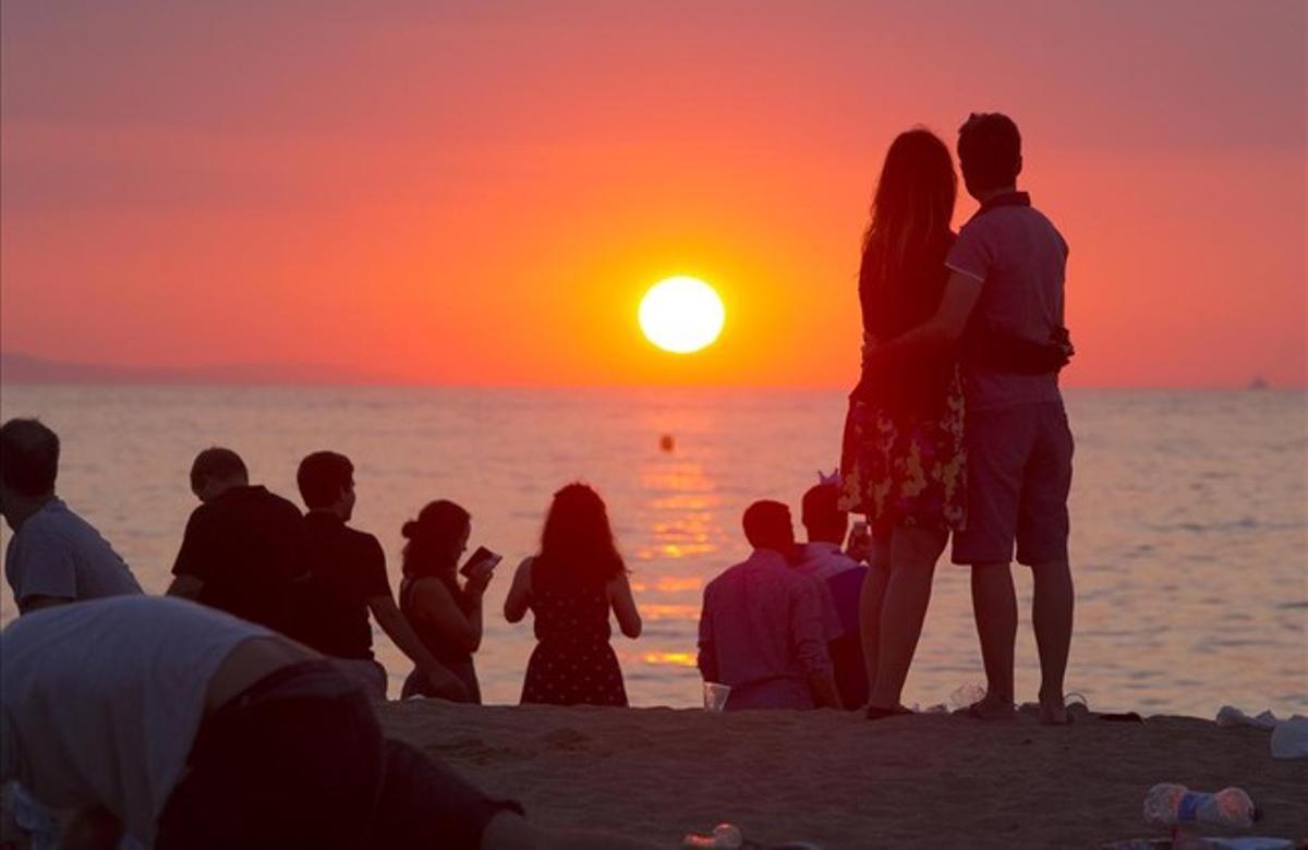 Surt el sol a la platja de la Barceloneta després de la celebració de la revetlla de Sant Joan a Barcelona.