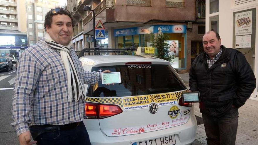 Dos de los taxistas del teletaxi exhiben los dispositivos que les mantienen comunicados con la central y los clientes. // Noé Parga