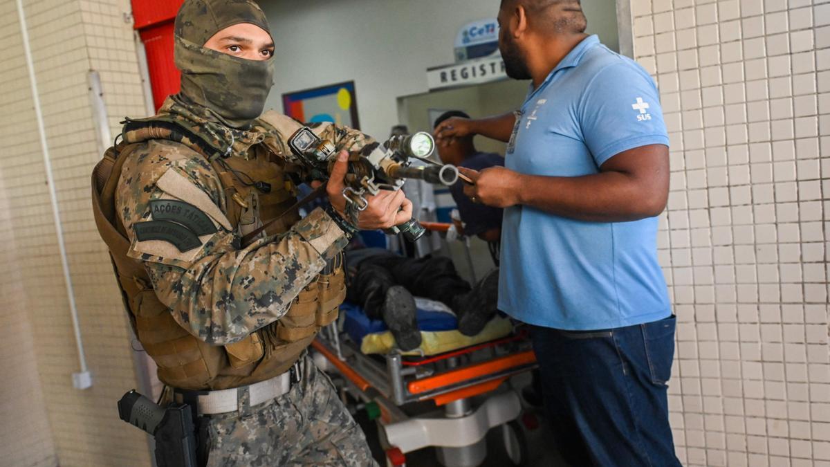 Un policía custodia la entrada en el hospital de uno de sus compañeros heridos durante la operación en una favela de Rio de Janeiro en la que murieron al menos 11 personas.