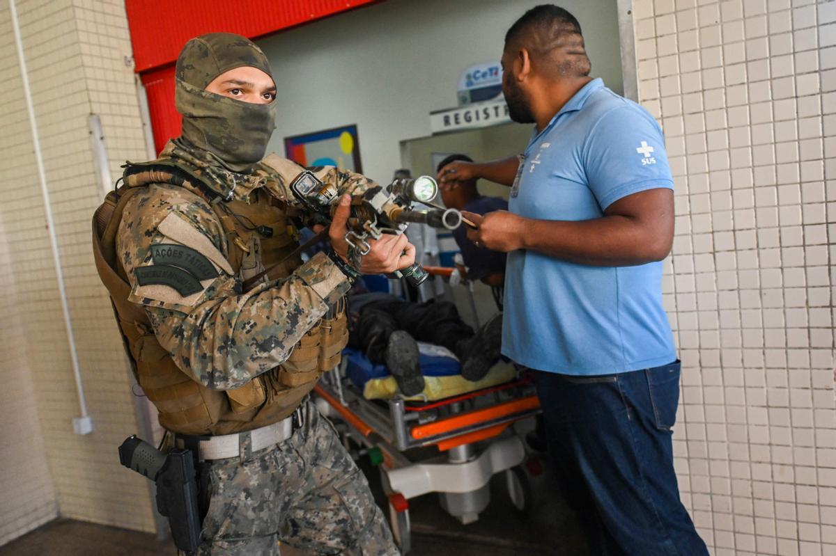 Un policía custodia la entrada en el hospital de uno de sus compañeros heridos durante la operación en una favela de Rio de Janeiro en la que murieron al menos 11 personas.