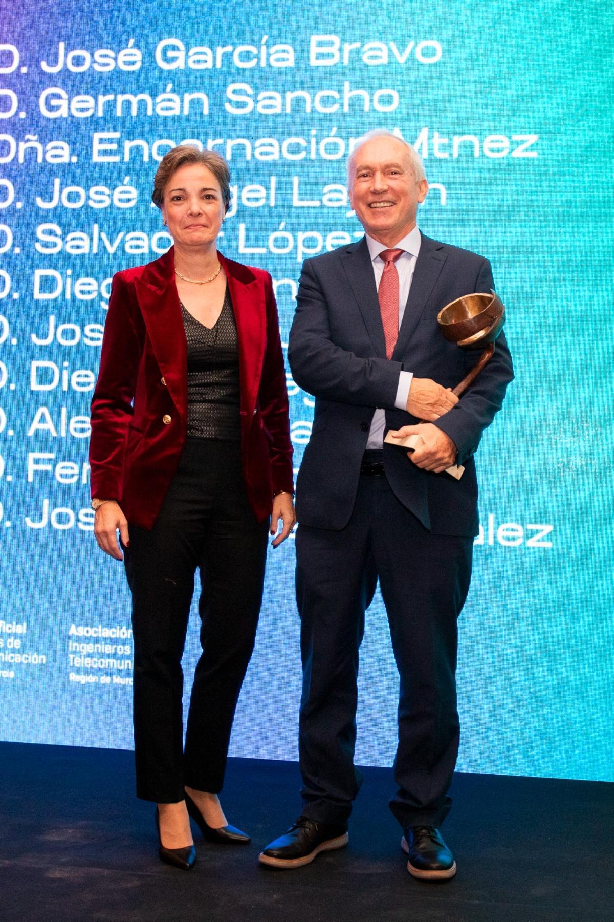 Benito Úbeda Miñarro recoge el premio de manos de la decana del Colegio Oficial de Ingenieros de Telecomunicación, Marta Balenziaga.