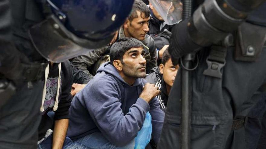 Varios refugiados esperan en la entrada del centro de acogida de Opatovac (Croacia), en la frontera con Serbia.