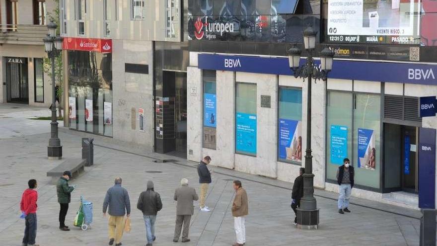 Colas para acceder a una entidad bancaria en la céntrica Plaza de Galicia. // Iñaki Abella