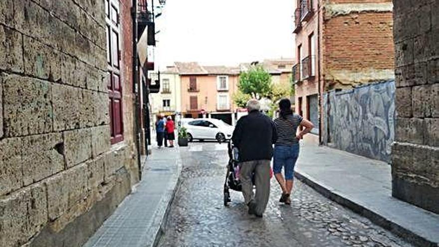 Un hombre mayor llevando un carrito de un bebé.