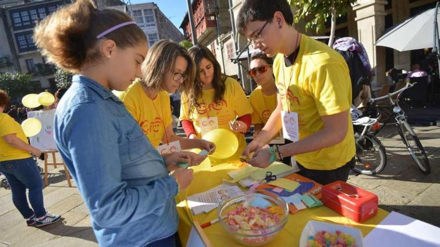 Arriba y a la izda., actividades de información y animación con las que se presentó ayer en A Ferrería el Movimiento España por la Infancia. // Gustavo Santos