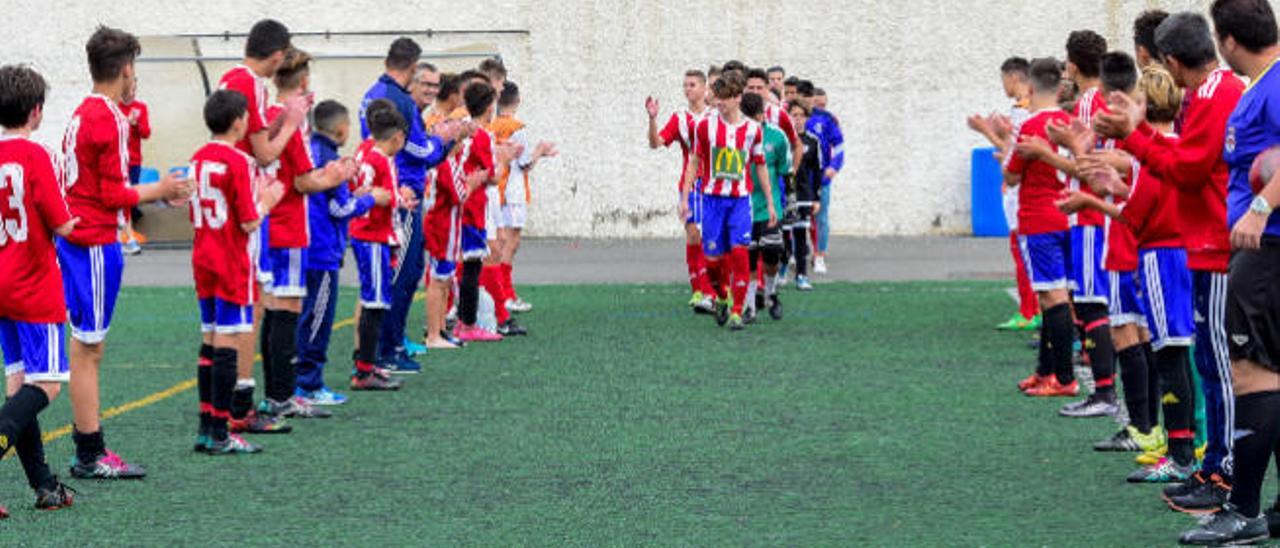 Ayuose, con el balón, poco antes de marcar el primer gol. En el centro, el pasillo que le hicieron jugadores del Acodetti e infantil B del Atlético al campeón, y una acción de ataque del local Jorge.