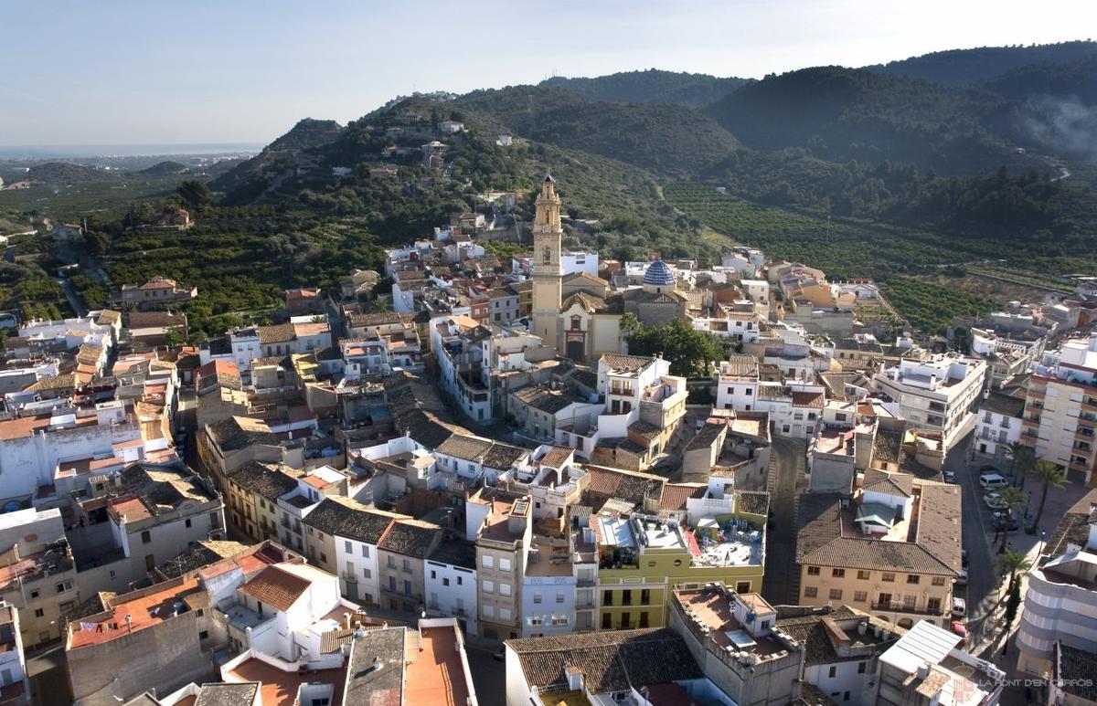 Vista de la Font d'en Carròs con el Calvari en la parte más alta, en la montaña.
