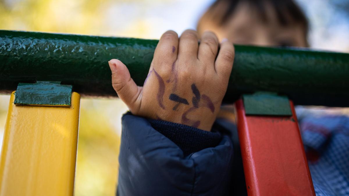 Un niño juega en el patio de un colegio.