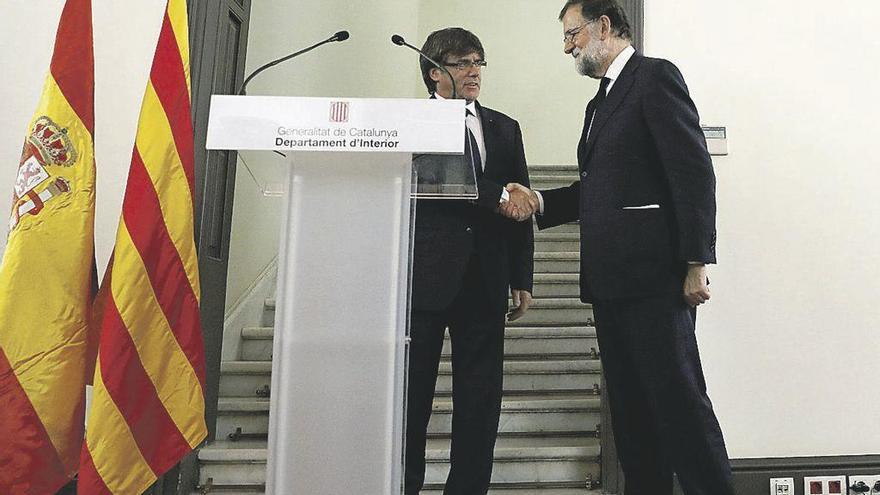 Rajoy y Puigdemont se saludan tras la reunión del gabinete de crisis. // Efe