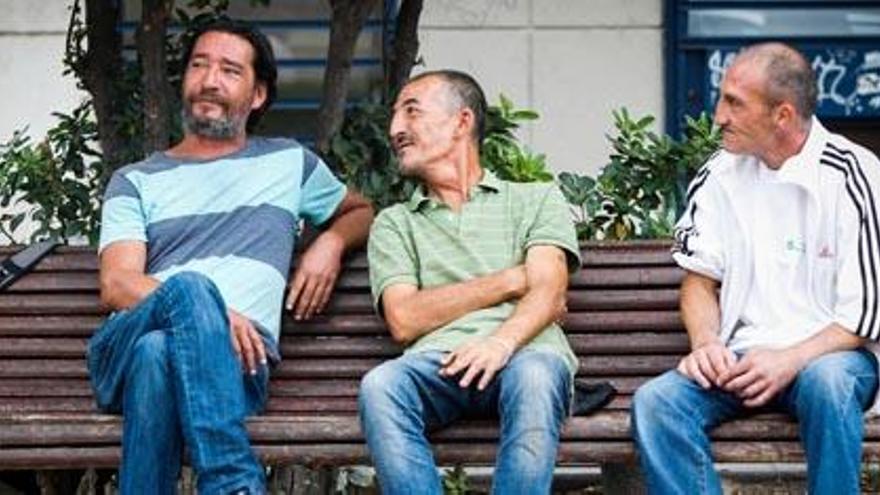 José, Luis y Andrés, tres personas sin hogar en un banco de Guillem de Castro, en Valencia.