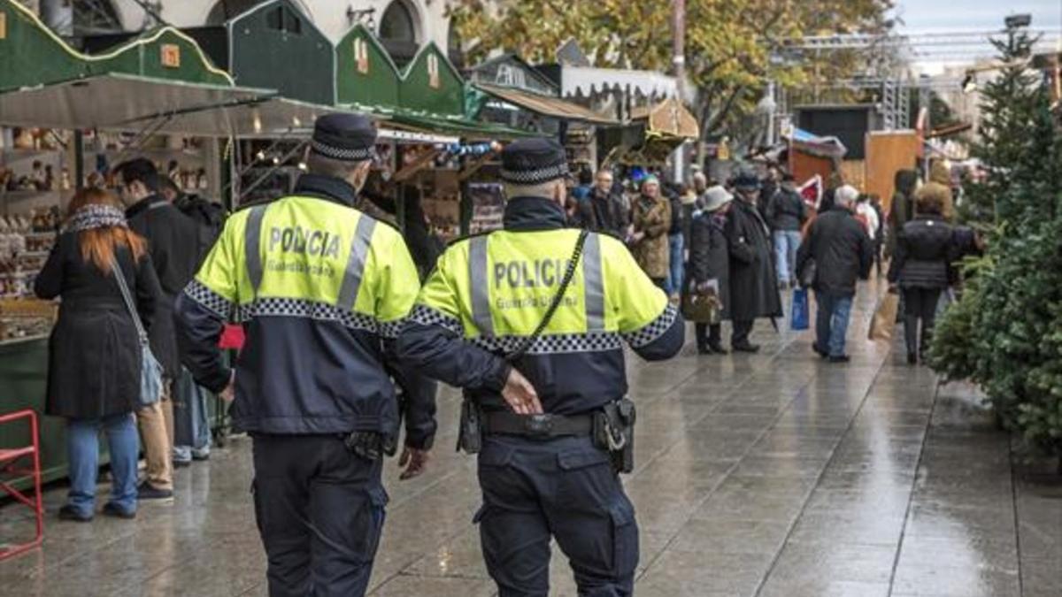 Dos agentes de la Guardia Urbana patrullan ayer por el mercado de santa Llúcia.