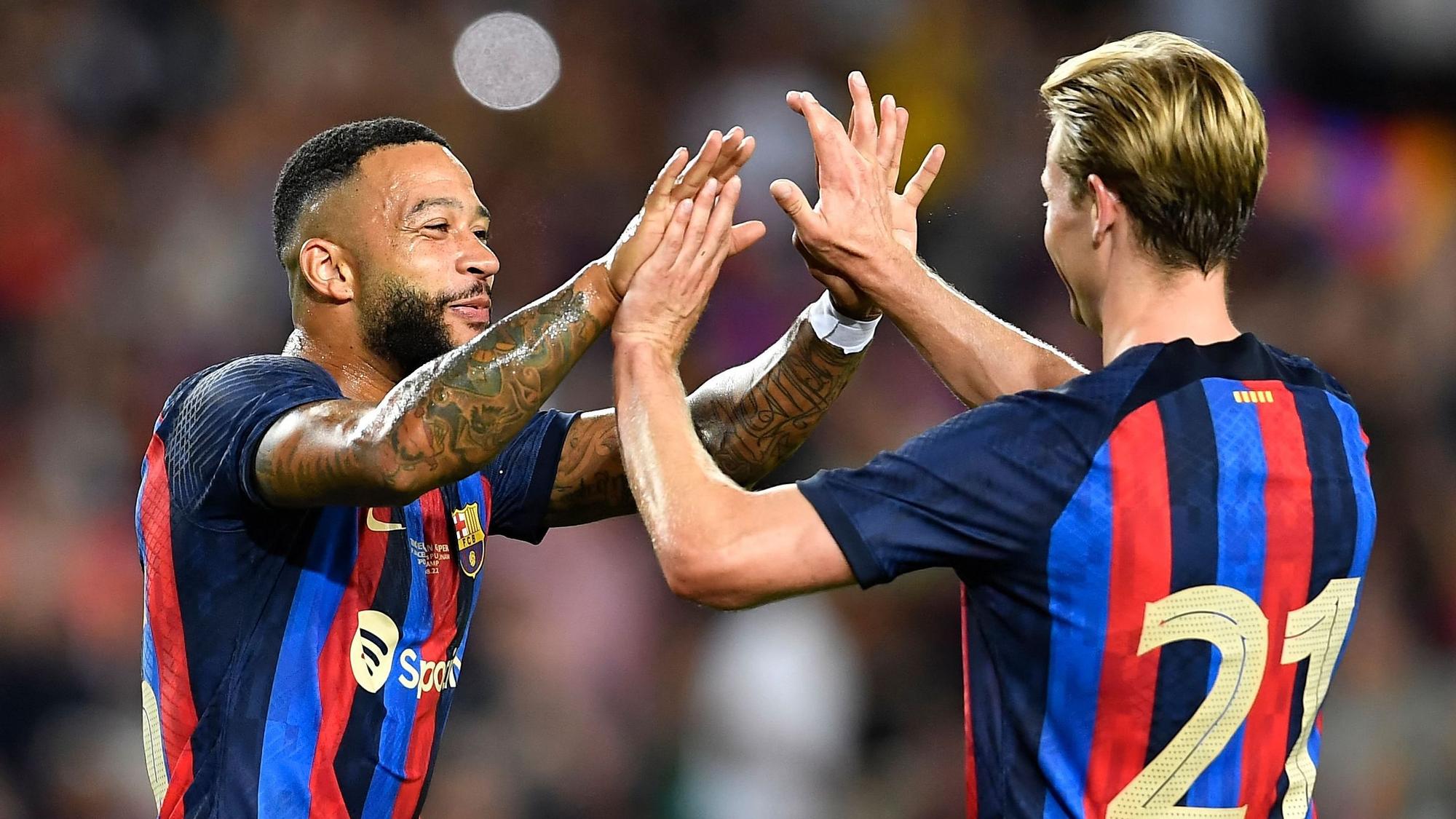 Barcelona's Dutch midfielder Frenkie De Jong (R) celebrates with Barcelona's Dutch forward Memphis Depay after scoring a goal during the 57th Joan Gamper Trophy friendly football match between FC Barcelona and Club Universidad Nacional Pumas at the Camp Nou stadium in Barcelona on August 7, 2022. (Photo by Pau BARRENA / AFP)