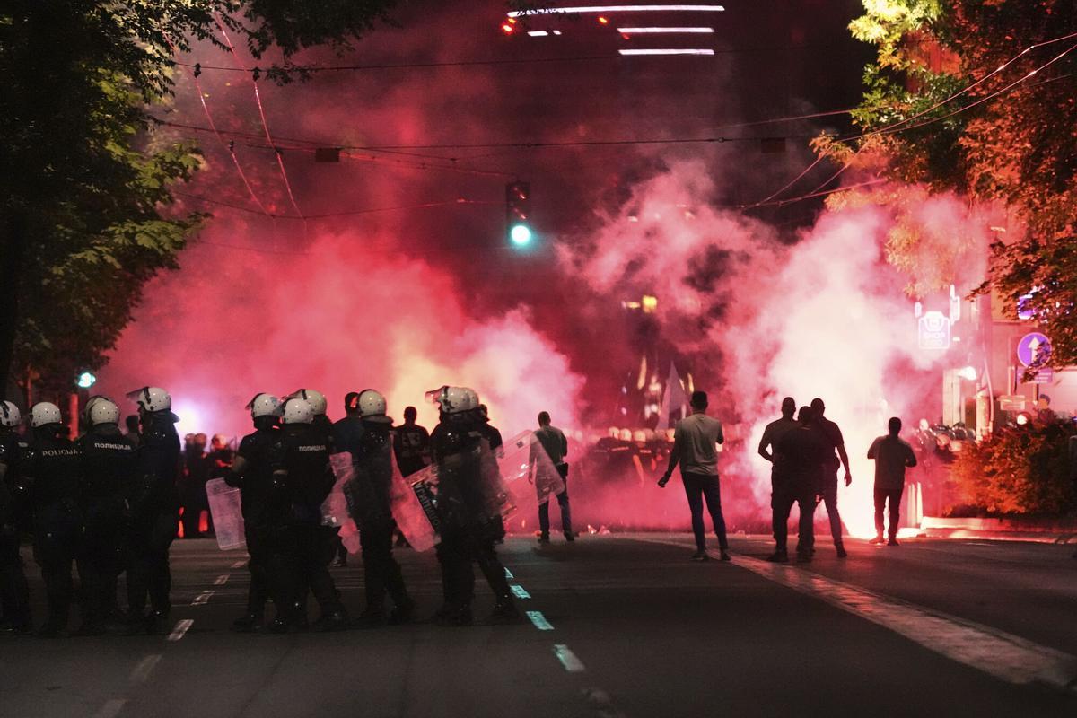 Riot police block a street as anti-government protesters light flares at the end of a rally pressing for an early election after nearly eight months of almost daily anti-corruption demonstrations that have shaken the populist government of President Aleksandar Vucic, in Belgrade, Serbia, Saturday, June 28, 2025. (AP Photo/Darko Vojinovic)