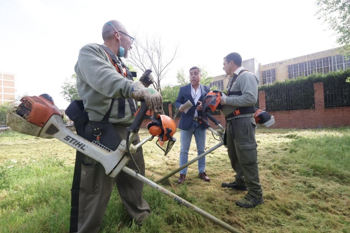 Ruiz Madruga conversa con trabajadores de Sadeco que se encargan de desbrozar un solar en el barrio de la Fuensanta.